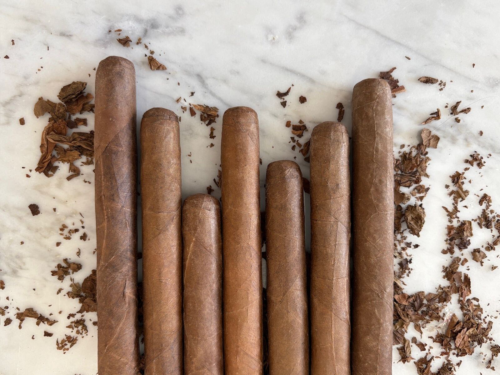 Puros de distintas vitolas en fila sobre mármol